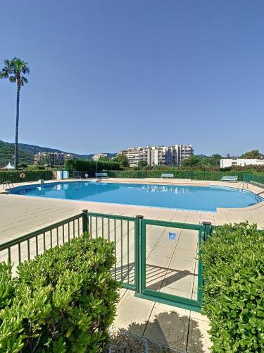 une grande piscine entourée d'une clôture. dans l'établissement Master - 4 pers 43m2 - Piscine - Climatisé, à Mandelieu-la-Napoule