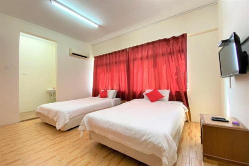 a hotel room with two beds and a tv at B Hotel Penang in George Town