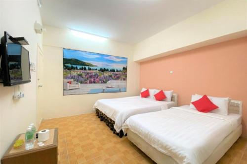two beds in a room with a painting on the wall at B Hotel Penang in George Town