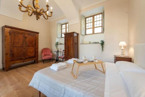 a bedroom with a large white bed and a table at Casa Abelli Bilocale in centro ad Alpignano in Alpignano