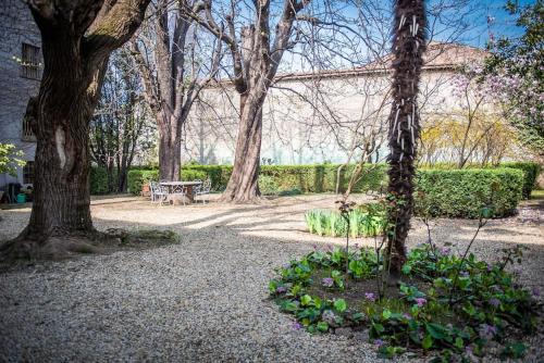 a park with trees and a bench and flowers at Casa Abelli Bilocale in centro ad Alpignano in Alpignano