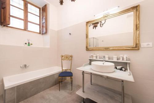 a bathroom with a sink and a tub and a mirror at Casa Abelli Bilocale in centro ad Alpignano in Alpignano