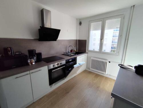 La cuisine est équipée de placards blancs et d'un four avec plaques de cuisson noires. dans l'établissement L'eskale, à Valence