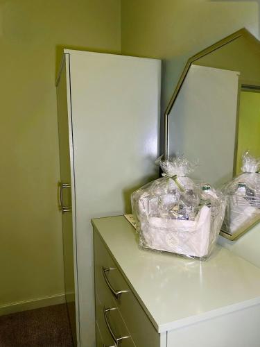 a room with a cabinet with two bags on it at The Rosemary Stay in Hull