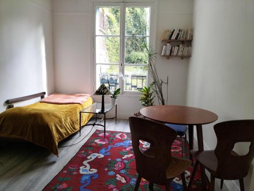 une chambre avec un lit, une table et des chaises dans l'établissement Appartement T3 lumineux et cosy, à Paris