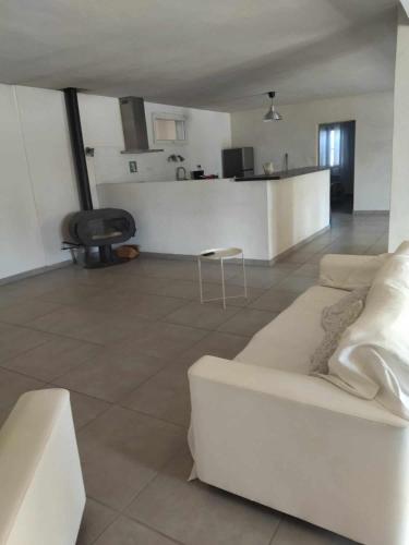 un salon avec un canapé blanc et une table dans l'établissement Ecurie Le Pas du Loup, à Caumont-sur-Durance