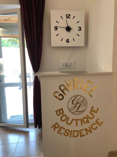 a clock on a wall next to a sign with the syracuse outdoor reserves sign at Gavriel Boutique Residence Wellness Spa in Szada