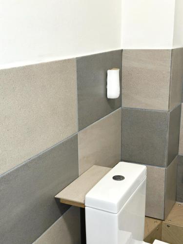 a bathroom with a white toilet and a wall at The Rosemary Stay in Hull