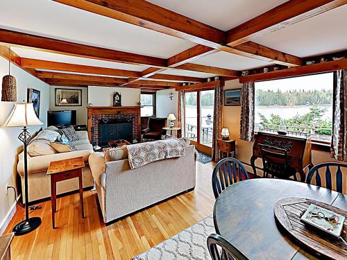 a living room with a couch and a table at Noonie's Nest Waterfront Cottage on Mount Desert Isle in Pretty Marsh