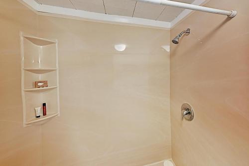 a bathroom with a shower with a toilet and shelves at Noonie's Nest Waterfront Cottage on Mount Desert Isle in Pretty Marsh