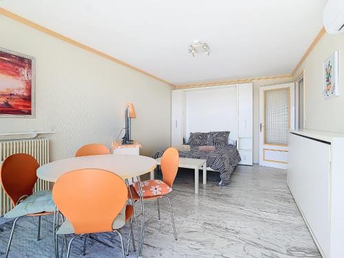 un salon avec une table, des chaises et un canapé dans l'établissement Montfleury - Studio 28m2 - Vue mer - Centre, à Cannes