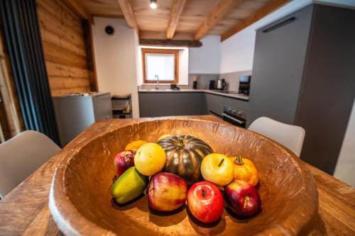 a bowl of fruit on a wooden table in a kitchen at Chalet 181 - Aosta Valley Mountain Stay in Arvier