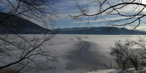 a view of a frozen lake with mountains in the background at Ferienwohnung Schloss-See-Bergblick in Waldeck
