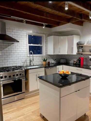 a kitchen with white cabinets and a bowl of fruit on a counter at Sparrowhawk House in Yarmouth