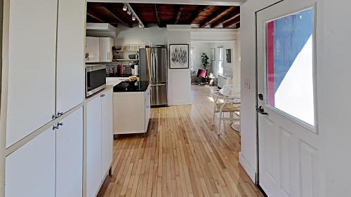 a kitchen with white cabinets and a wooden floor at Sparrowhawk House in Yarmouth