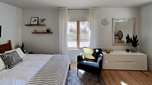 a bedroom with a bed and a chair and a mirror at Sparrowhawk House in Yarmouth