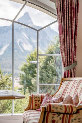 a room with a couch and a large window at Wellness & Sporthotel Alpenhof in Ehrwald