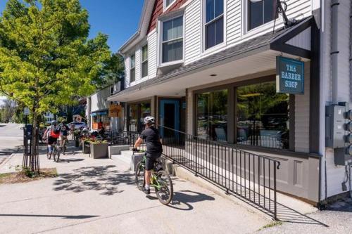 a man riding a bike down a sidewalk in front of a store at Sparrowhawk House in Yarmouth