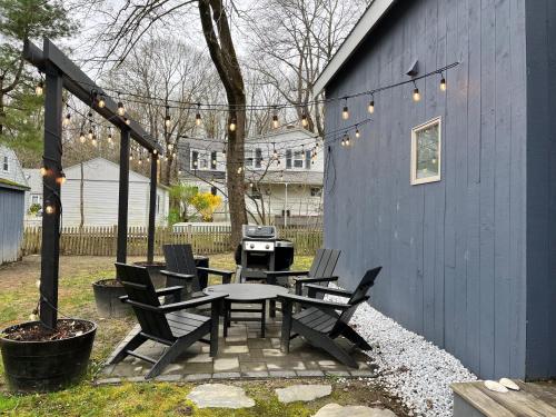 a patio with a table and chairs and a grill at Sparrowhawk House in Yarmouth