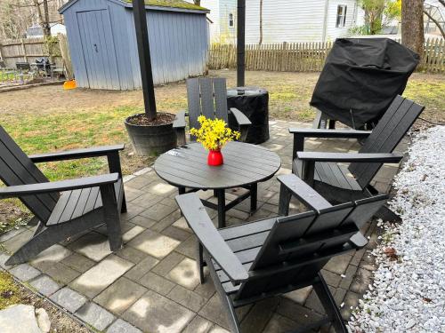 three chairs and a table with a vase of flowers at Sparrowhawk House in Yarmouth