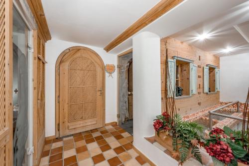 a hallway with a wooden door and a checkered floor at Wellness & Sporthotel Alpenhof in Ehrwald
