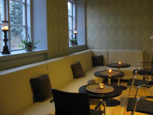 a waiting room with tables and chairs and windows at Åkeshofs Slott in Stockholm