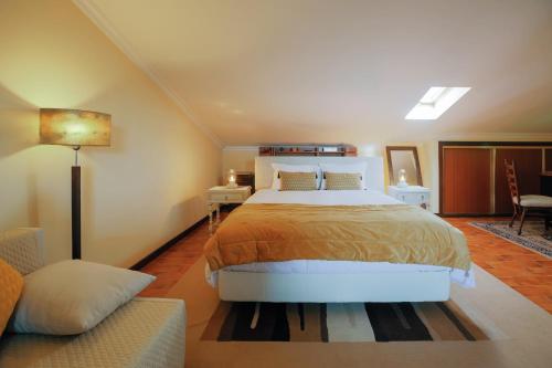 a bedroom with a large bed and a couch at Suíte Private balcony Hot Tub in Aguda