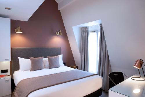 a bedroom with a large bed and a window at Hôtel Brady in Paris