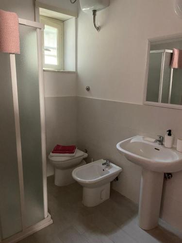 a white bathroom with a toilet and a sink at B&B Sole e Luna in Ponte Galeria