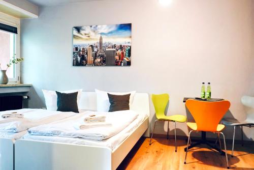 a bedroom with two beds and two chairs at Naturnahes Apartment- 3 Betten-Waschmaschine-Parkplatz-Balkon in Wolfsburg