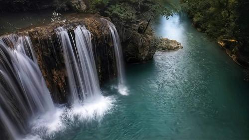 an aerial view of a waterfall in a river at Hotel Palazzo Renieri - 3stelle S in Colle Val D'Elsa