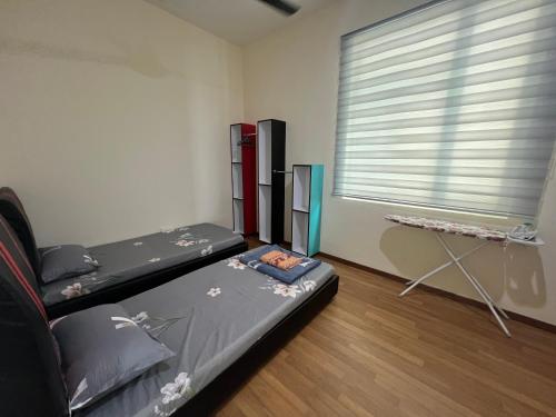 a room with two beds and a window at Sandakan Homestay & Backpackers in Sandakan