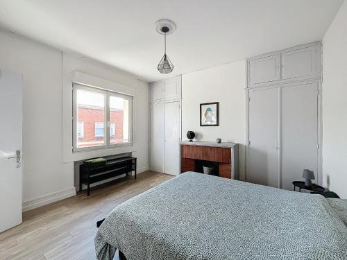 une chambre blanche avec un lit et une fenêtre dans l'établissement Appartement Dunkerque hyper centre, à Dunkerque