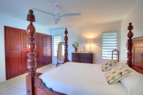a bedroom with a bed and a ceiling fan at Domaine Les hauts de Sofaia - Évasion Créole - Vue Spectaculaire in Sofaïa