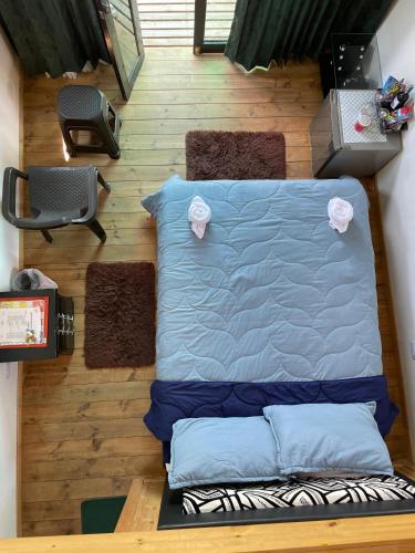 a bed sitting on a wooden floor with two pillows at El Alpino Cabaña Glamping & Camping in Guatavita