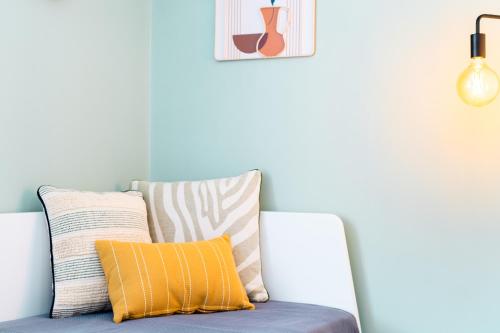 un canapé avec des coussins dessus dans un salon dans l'établissement Life&Travel - Appartement Cosy - Centre & Parking, à Limoges