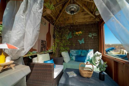 a porch with a couch and chairs in a house at Stunning Central Villa by Golf Course & Beach in Leven-Fife