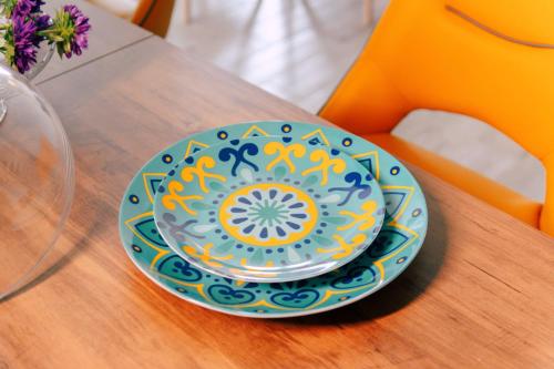 a colorful plate on a table with a vase at Massaria Donna Oliva in Buccino