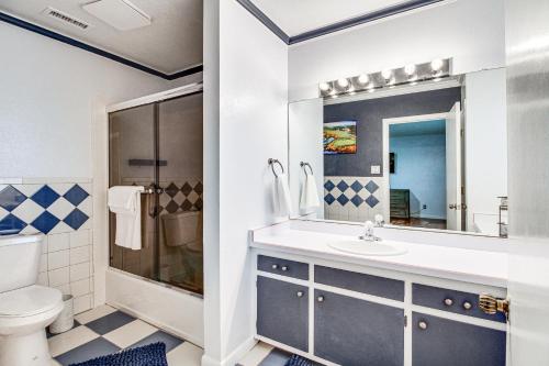 a bathroom with a sink and a toilet and a mirror at Walk to Paradise Hills Golf Course Condo with Patio in Albuquerque