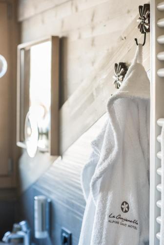 a white towel hanging on a wall next to a mirror at La Genzianella Bormio in Bormio