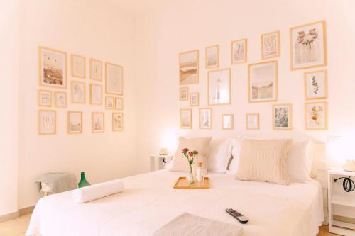 a bedroom with a white bed with pictures on the wall at Massaria Donna Oliva in Buccino