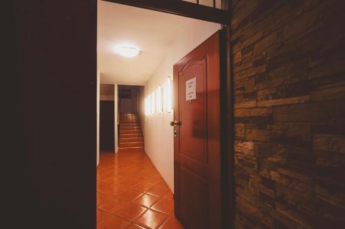 an empty hallway with a door and a brick wall at AMMOTTI Hotel in Ohrid