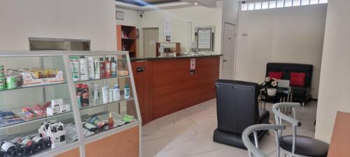 a salon with a waiting room with a chair and a counter at Hotel de Santa Maria in Santa Cruz del Quiché