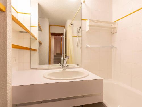 La salle de bains blanche est pourvue d'un lavabo et d'une baignoire. dans l'établissement Duplex rénové skis aux pieds, animaux admis à Valmorel - FR-1-356-294, à Valmorel