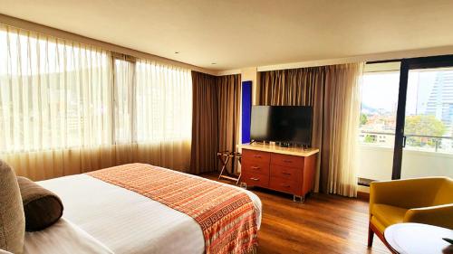 a hotel room with a bed and a flat screen tv at Bogota Plaza Hotel in Bogotá