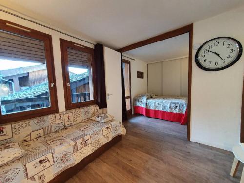 Cette chambre dispose d'une horloge murale et d'un lit. dans l'établissement Appartement cosy à La Plagne - 4 pers, balcon, animaux admis - FR-1-353-41, à La Plagne