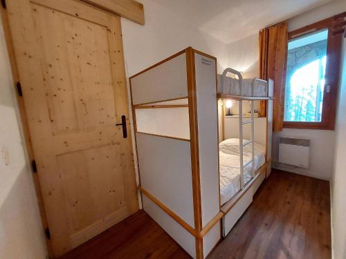 Cette petite chambre comprend des lits superposés et une porte. dans l'établissement Appartement 6 pers, 2 logements communicants, 2 terrasses, animaux admis - FR-1-353-64, à La Plagne