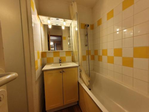une salle de bain avec un lavabo, une baignoire et un miroir dans l'établissement Appartement 6 pers, 2 logements communicants, 2 terrasses, animaux admis - FR-1-353-64, à La Plagne