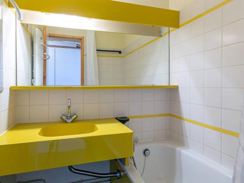 La salle de bains est pourvue d'un lavabo jaune et d'une baignoire. dans l'établissement Appart cosy pour 5 pers avec balcon proche pistes et commerces - FR-1-353-68, à La Plagne