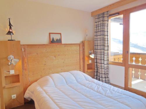 une chambre avec un lit et une grande fenêtre dans l'établissement Appartement spacieux 3 pièces, 6 pers, La Plagne - FR-1-353-33, à La Plagne